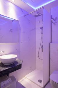 a white bathroom with a sink and a shower at Oceanis Hotel in Karpathos