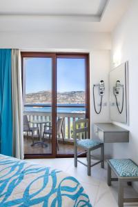 a bedroom with a bed and a view of the ocean at Oceanis Hotel in Karpathos