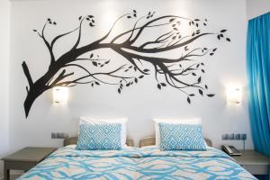 a bedroom with a tree vinyl wall decal at Oceanis Hotel in Karpathos