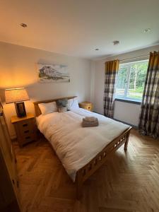 a bedroom with a large bed and a window at Luxurious Cottage on the River of Portree with Hot Tub! in Portree