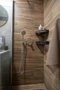 a shower in a bathroom with a wooden wall at Boho Nest in Glyfada by ΜΡS in Athens +38 photos