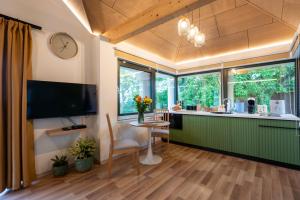 a living room with a kitchen with a table and a tv at VillaPince in Garabonc