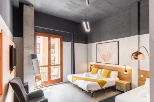 a bedroom with a bed and a chair in it at Brick Palma - Turismo de Interior in Palma de Mallorca