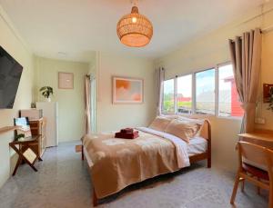 a bedroom with a bed and a large window at Baan Ploen Dee - Wat Arun in Bangkok