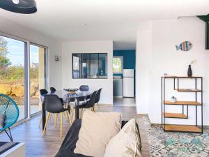 a kitchen and living room with a table and chairs at 354 - Maison neuve en plein cœur de Plévenon. in Plévenon +10 photos