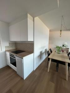 a kitchen with white cabinets and a table and a dining room at Playa centro Sada 4 dormitorios in Sada