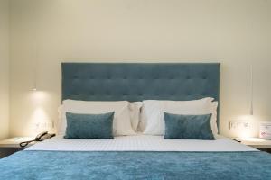 a bedroom with a large bed with blue sheets and pillows at Hotel Concordia Barcelona in Barcelona
