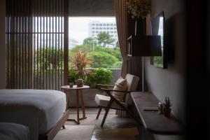 a bedroom with a bed and a table and a window at Wazen Retreat Villa Danang in Da Nang +142 photos