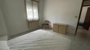 a bedroom with a bed and a chair and a window at Villa Laura 1 Piano in Lido di Pomposa +7 photos