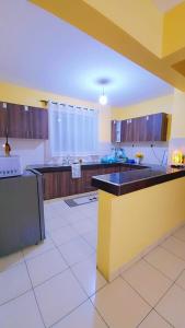 a large kitchen with a large island in the middle at Marvel Homes Two Bedroom Air-Bnb Mombasa Bamburi in Bamburi
