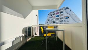 un balcon avec une table et des chaises et un bâtiment dans l'établissement Le Temple du Soleil, Mer et Plage, à La Grande Motte