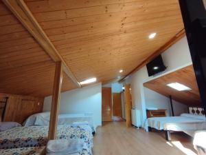 a bedroom with two beds and a wooden ceiling at Casa Rural Los Pinos in La Adrada +18 photos