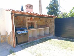 an outdoor kitchen with a stove in a backyard at Casa Rural Los Pinos in La Adrada