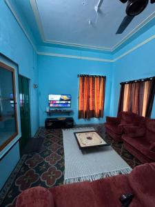 a living room with a couch and a tv at JMS Holiday homes in Coonoor
