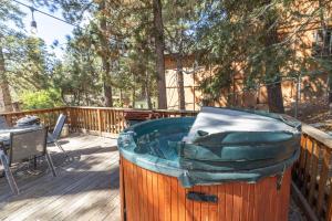 a wooden deck with a bath tub on a deck with a table at True Big Bear Lake Cabin with jacuzzi, Netflix in Big Bear Lake
