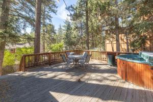 a deck with a table and chairs and a pool at True Big Bear Lake Cabin with jacuzzi, Netflix in Big Bear Lake