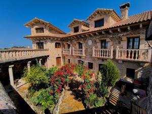 un grande edificio con dei fiori di fronte di Hotel Rural El Cañón del Duratón en Villaseca de Sepúlveda a Sepúlveda