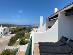 een balkon met twee stoelen en uitzicht op de oceaan bij C-4 by SOM Menorca in Son Parc