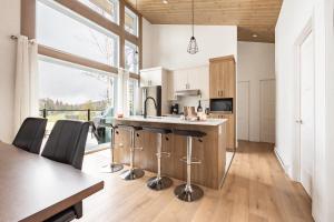 eine Küche mit einer Theke und ein paar Stühlen darin in der Unterkunft Ski Condo & Spa - L'Elegance Des Sommets in Adstock