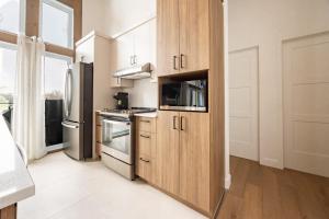 eine Küche mit Holzschränken und einem Edelstahlkühlschrank in der Unterkunft Ski Condo & Spa - L'Elegance Des Sommets in Adstock + 29 Fotos