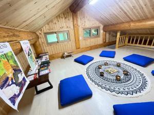 an attic room with a table and blue chairs at mindfulstay in Hami