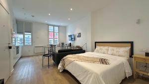 a bedroom with a bed and a chair in it at CoruñaFlat Apartments - Centro A Coruña in A Coruña