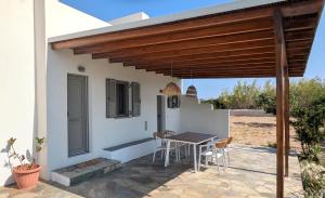 a patio with a table and chairs under a wooden pergola at KONAKI Private Villa in Skiros