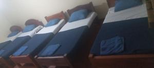 three twin beds with blue and white sheets at Misty Mountain Lodge - Uduweria Ohiya in Ohiya