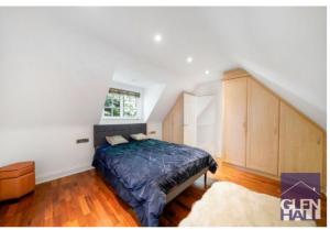 a bedroom with a bed and a window in a attic at The Mews, N14 in New Southgate