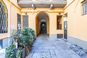 an alleyway leading to a building with a black door at RELSTAY - Brera District in Milan