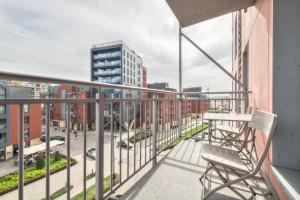 a balcony with a chair and a view of a city at Grand Apartments - Apartments SPA Waterlane Island in Gdańsk
