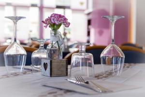 a table with three wine bottles and a flower in a vase at Piccolo Hotel in Terracina