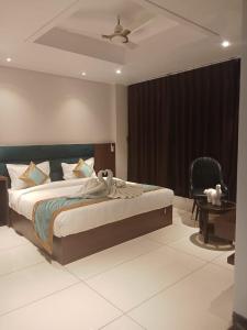 a bedroom with a large bed and a chair at Hotel Kamakhya Inn in Chhatarpur