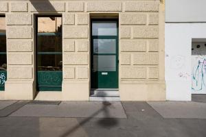 ein Gebäude mit grüner Tür auf einer Straße in der Unterkunft Grand Viennese Residence in Wien