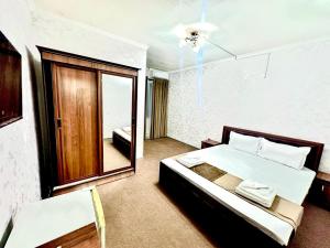 a bedroom with a large bed and a mirror at Hafiz Plaza Hotel in Tashkent