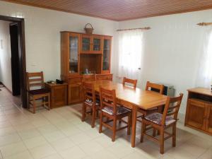 comedor con mesa de madera y sillas en House Andrade, en Praia do Norte