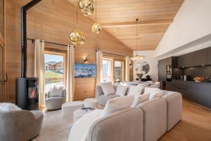 un soggiorno con mobili bianchi e soffitti in legno di Apartment Nivalis Alpe D'Huez - by EMERALD STAY a LʼHuez