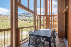 un tavolo e sedie su una veranda con vista sulle montagne di Apartment Nivalis Alpe D'Huez - by EMERALD STAY a LʼHuez