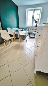a kitchen with a table and a table and chairs at Komfortowy Apartament in Debrzno
