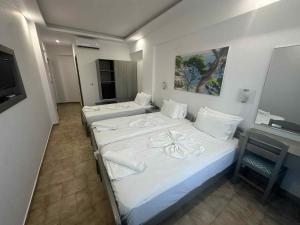two beds in a room with a tv at Oceanis Hotel in Karpathos