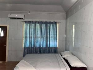 a large bed in a room with a window at Maninoa Surf Accommodation in Apia