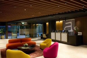 eine Bürolobby mit bunten Stühlen und einem Tisch in der Unterkunft Aloft Dublin City in Dublin