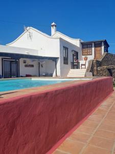 a house with a swimming pool in front of it at Lanzarote Ysabela Only Adults in Tías
