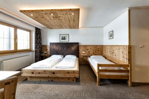 two beds in a room with two windows at Appartementanlage Kerber in Seefeld in Tirol