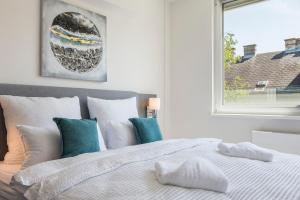 Un dormitorio con una gran cama blanca con almohadas azules. en Cube Apartments - Contactless Check In - Stadthalle U3 Metro, en Viena