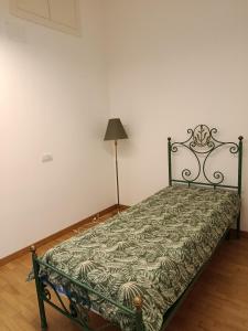 an empty bed in a room with a lamp at Salerno Eremita Apartment in Salerno