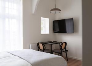 a bedroom with a table and a tv on the wall at Limehome London Streatham High Rd in London +29 photos