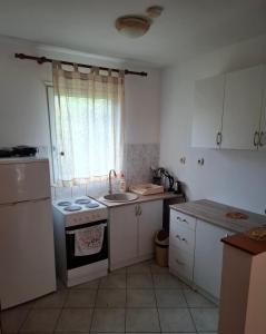 a kitchen with a stove and a sink and a window at Macy in Kotor