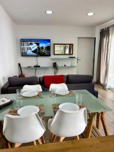 a dining room with a green table and white chairs at Casa Miká in Parede