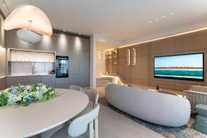 a living room with a white table and a tv at Villa Alma Eilat in Eilat